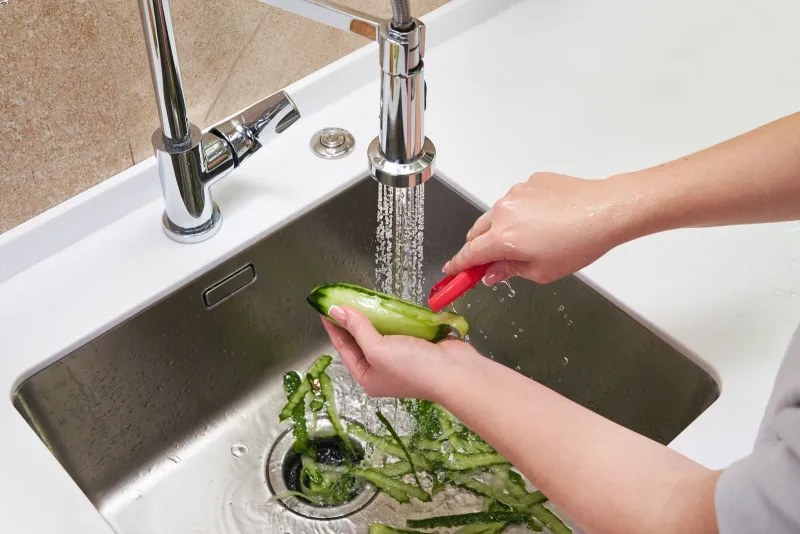 a person washing vegetables in a sink