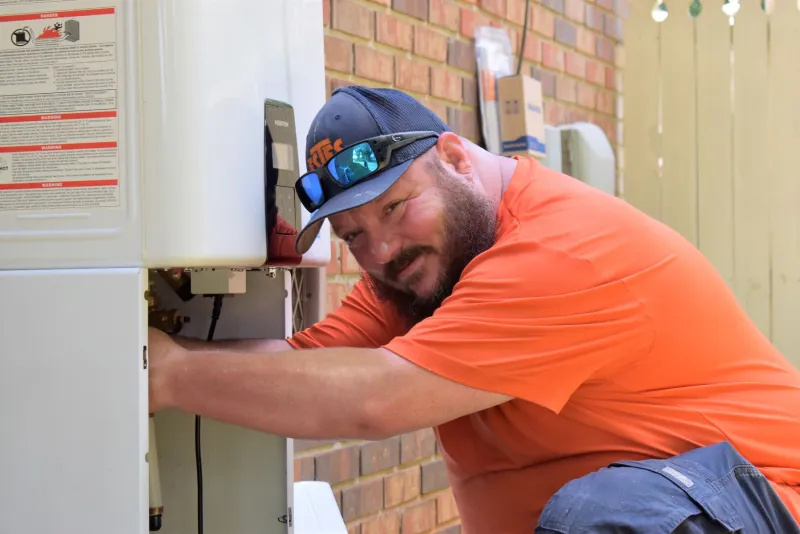 Atlanta water heater expert at Estes Services performing a repair