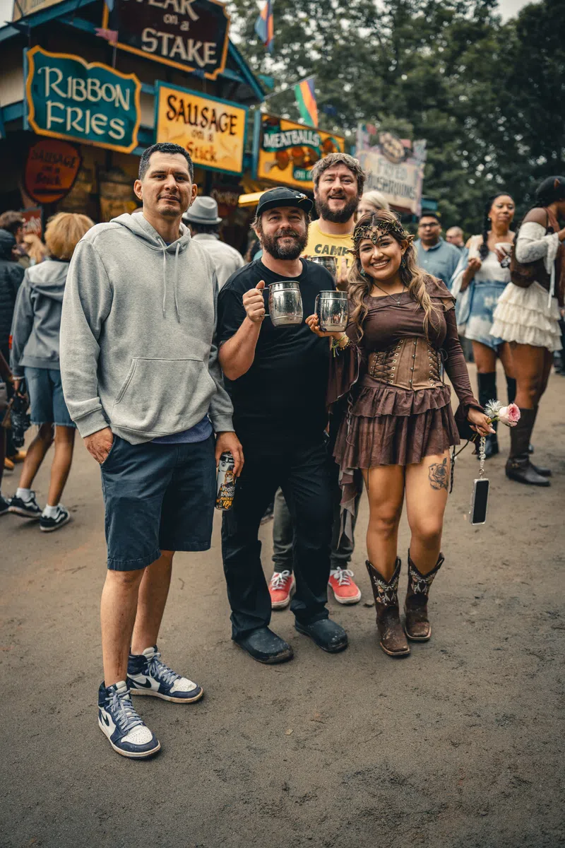 A group of friends raising mugs together at the Festival.