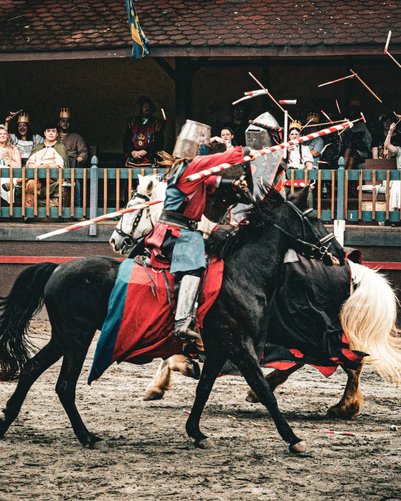 Armored knights on horseback competing in a live joust at the Georgia Renaissance Festival