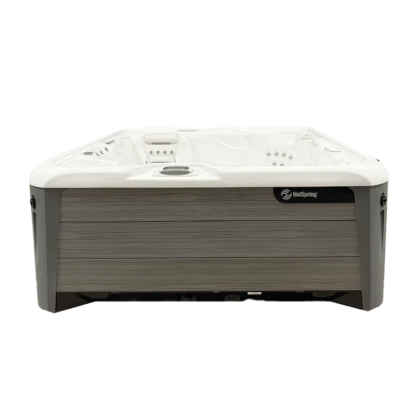 Modern rectangular HotSpring hot tub with white interior and gray wood panel exterior.