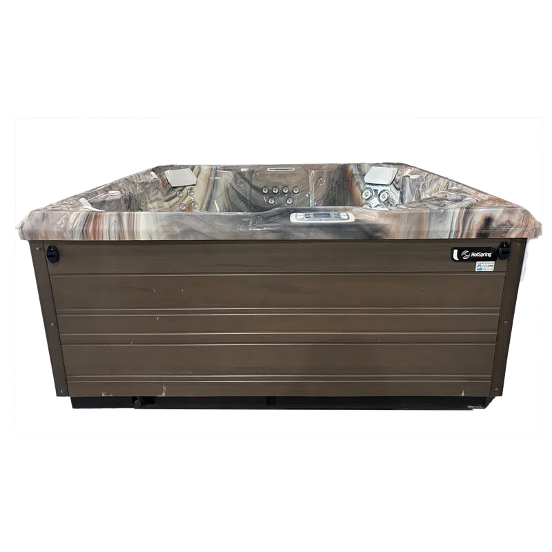 Modern HotSpring spa hot tub with wood siding and multiple jet controls for hydrotherapy relaxation.