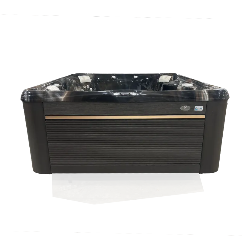 Modern black and gray hot tub with multiple jets and headrests on a concrete floor.