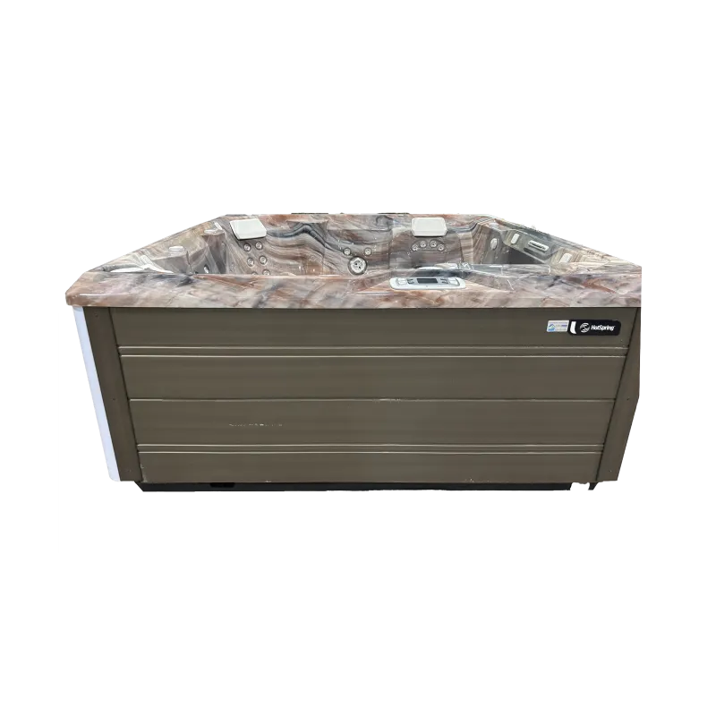 Brown and beige marble-patterned hot tub with control panel and multiple jet seats, isolated on black background