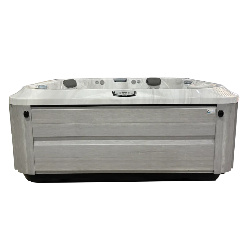 Modern rectangular hot tub with gray wooden panel exterior and white marble interior with control panel.
