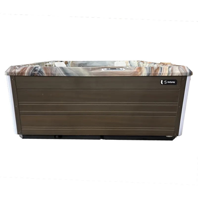 Modern HotSpring hot tub with wood paneling and marble-like top edge isolated on white background.
