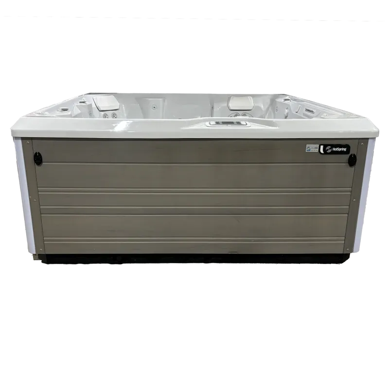 Modern rectangular outdoor hot tub with white interior and beige paneling, featuring built-in headrests and control panel.