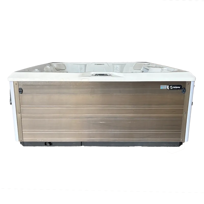 Modern HotSpring brand outdoor hot tub with wood paneling and white acrylic interior seating.