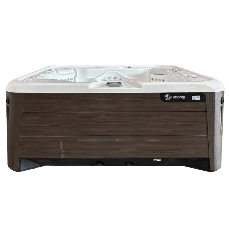 Modern HotSpring hot tub with white interior and wood-textured exterior paneling, three seats with jets.