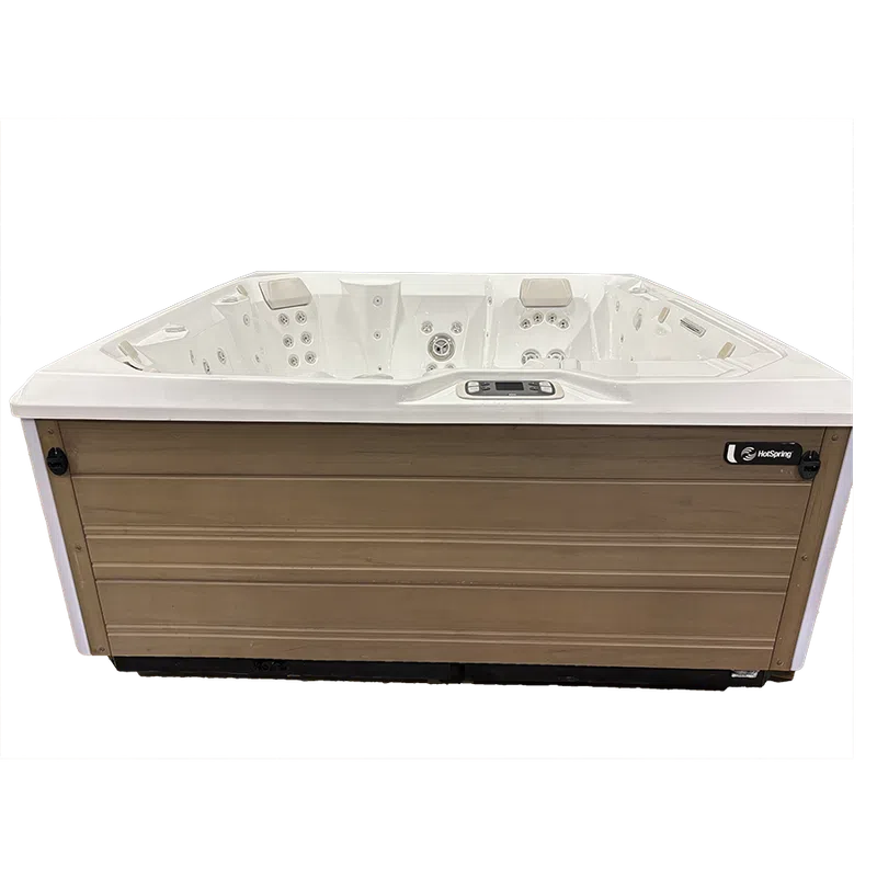 Rectangular HotSpring brand white spa with wood panel surround, multiple jets, control panel, on transparent background.