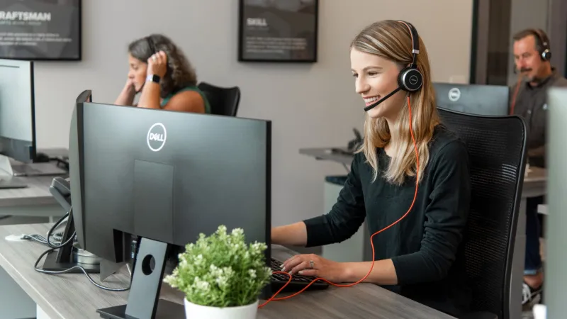 a woman wearing headphones and sitting at a computer