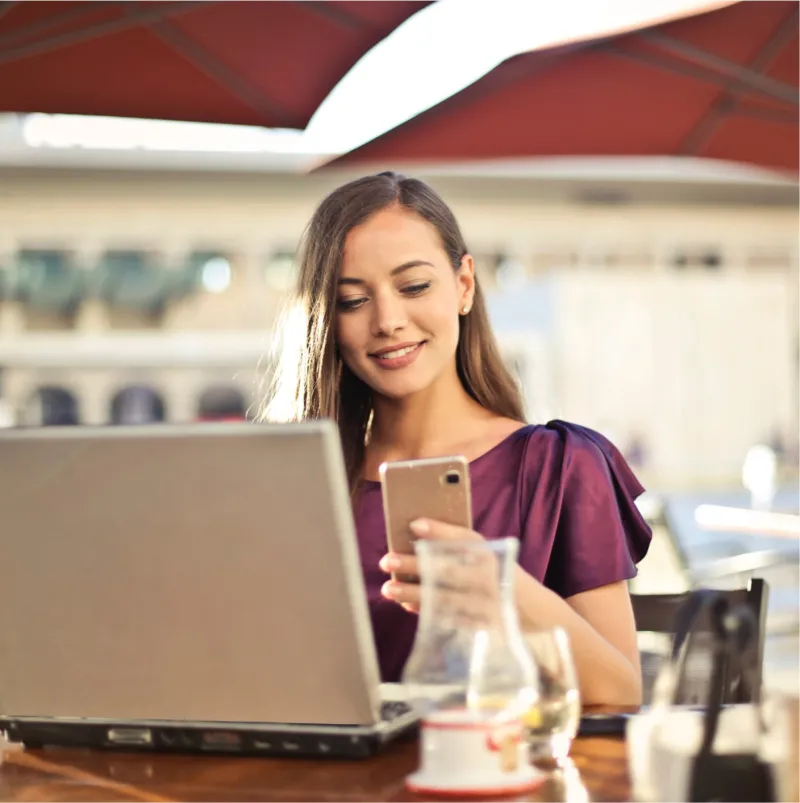 a woman sitting at a table in front of a laptop