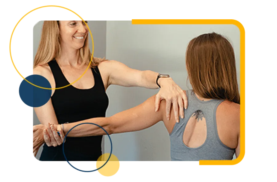 Female trainer helping woman with shoulder stretch exercise in a fitness session indoors