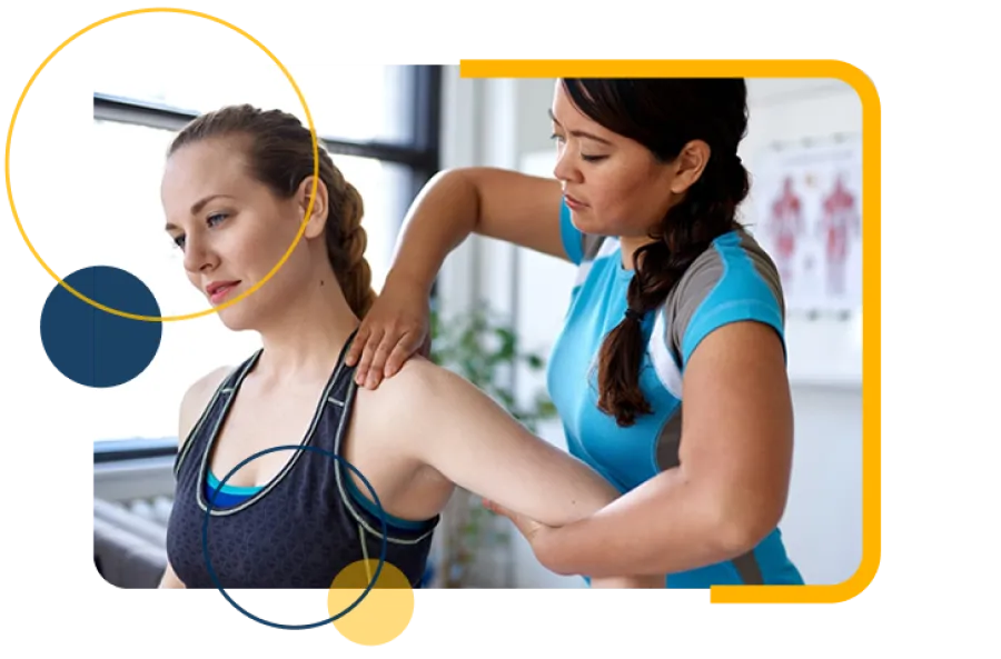 Trainer assisting woman in gray sports bra with arm stretch during fitness session indoors.
