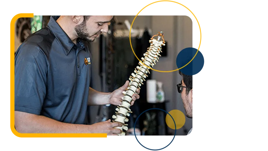 Chiropractor performs spinal adjustment on patient lying face down on treatment table in clinic.