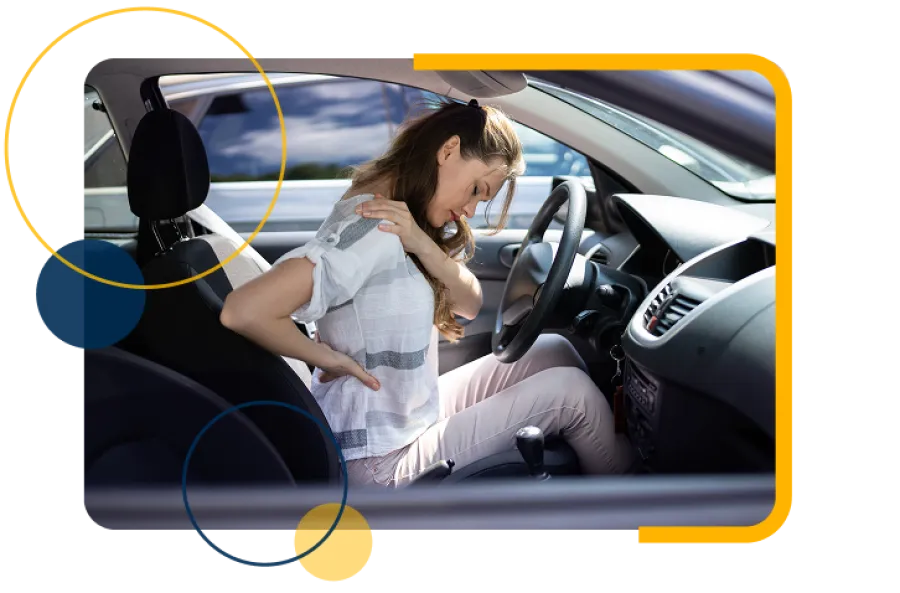 Woman sitting in car seat holding her lower back in pain showing discomfort from sitting.