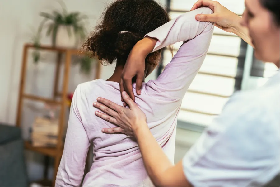 Hands giving a relaxing back massage on bare skin in a calm indoor setting.