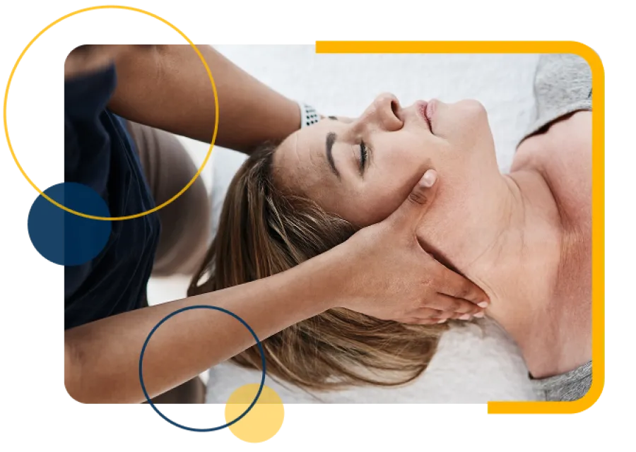 Therapist giving a relaxing neck massage to a woman lying on a towel with eyes closed.