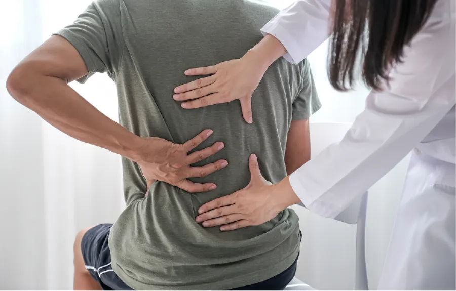 Chiropractor adjusting patient lying on treatment table in wellness clinic with colorful wall background.