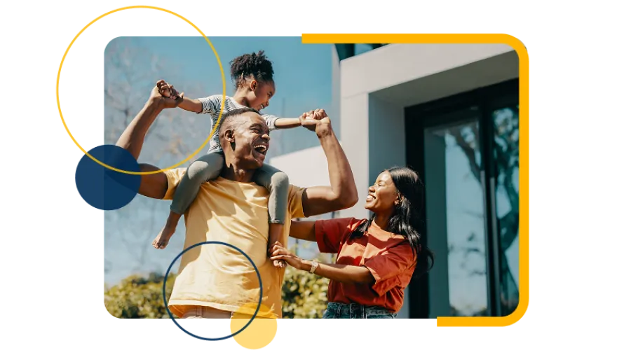 Happy family enjoying time together outside their modern home on a sunny day with playful child on father's shoulders