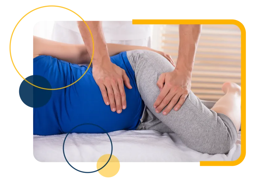 Physical therapist performing hip stretch on patient lying on side during rehabilitation session