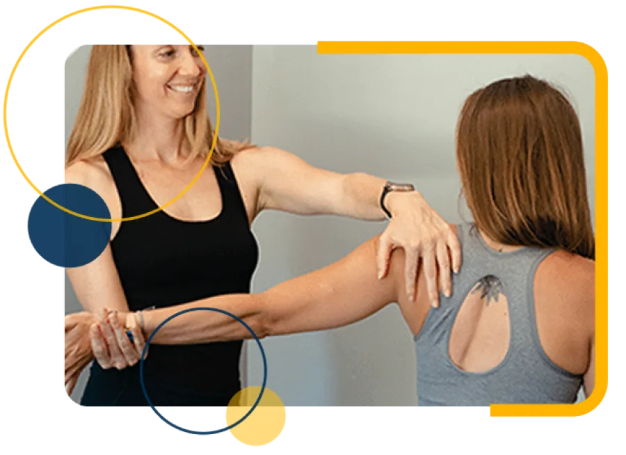 Fitness trainer assisting a woman with shoulder stretching exercise in a wellness setting.