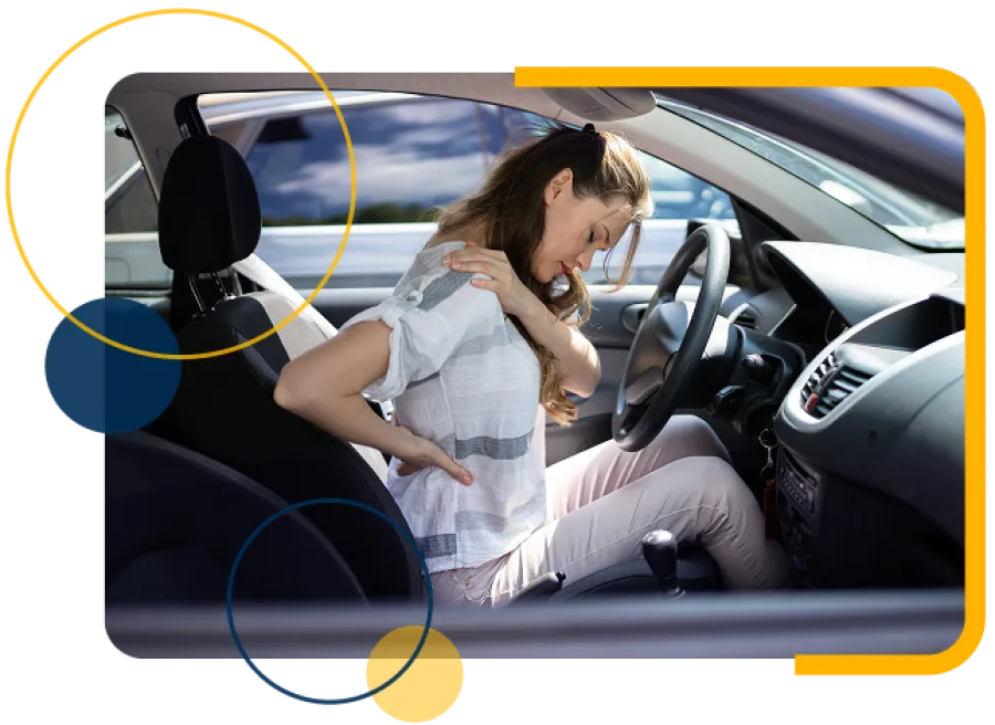 Young woman sitting in car experiencing back pain while holding her lower back and shoulder.