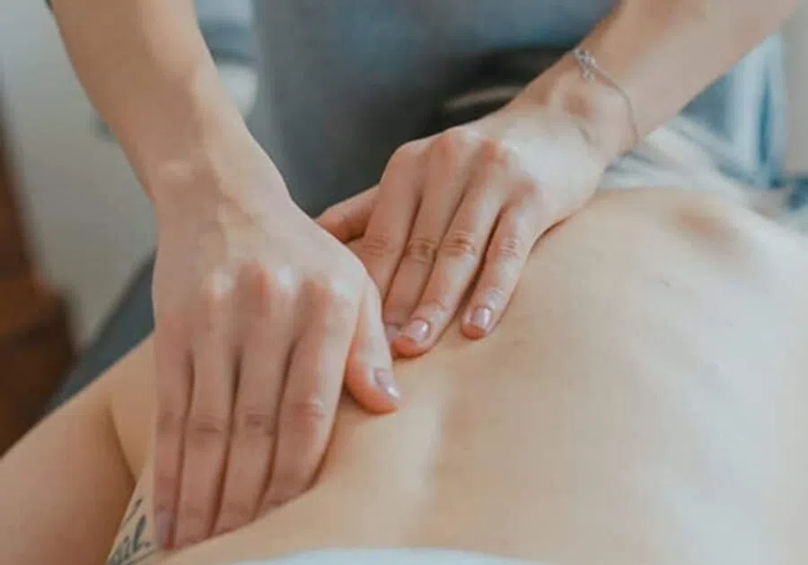 Close-up of hands giving a back massage on a person's bare skin for relaxation or therapy.