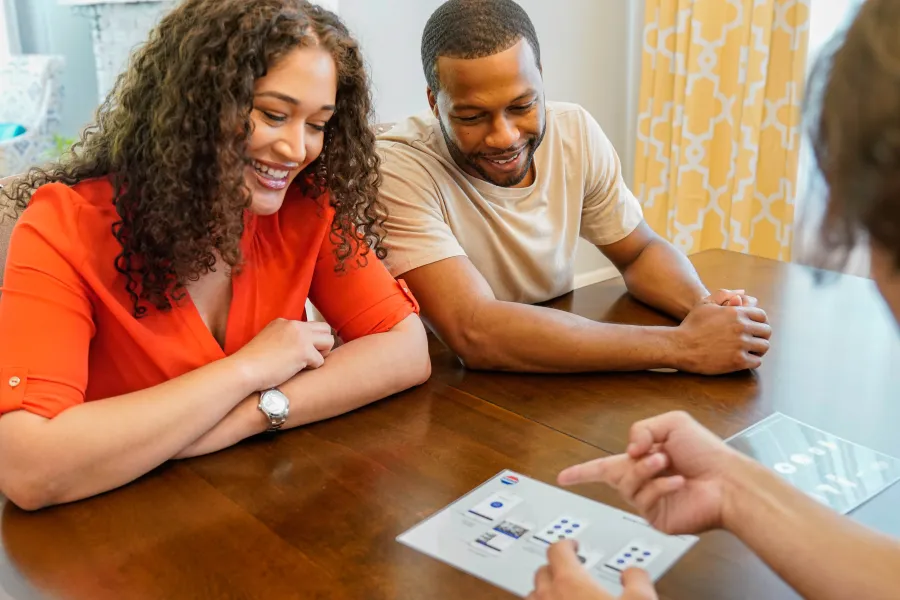 people sitting at a table and looking at a paper