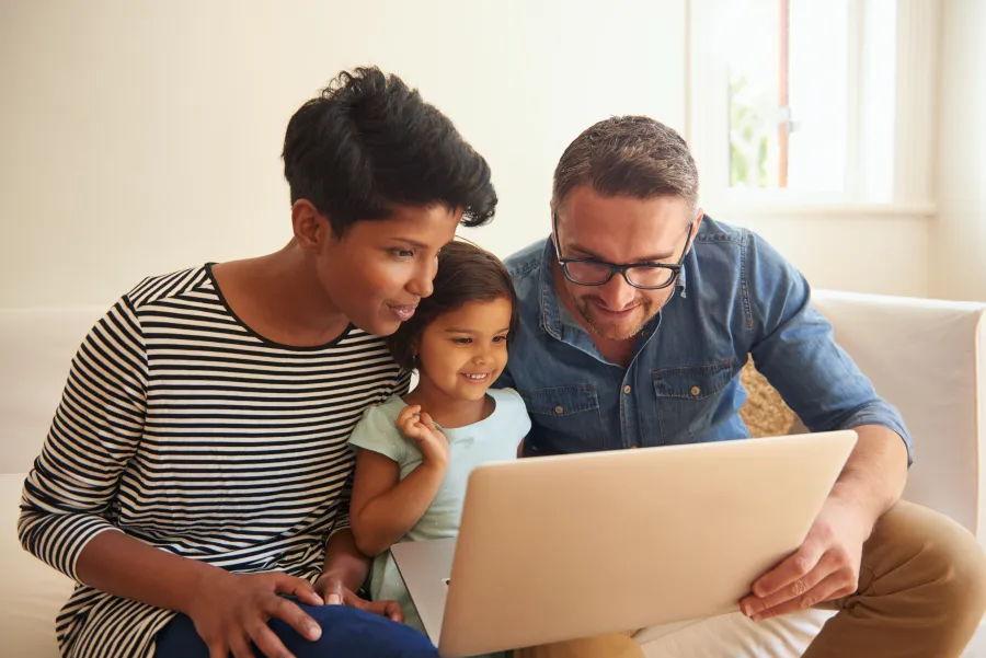a family looking at a laptop