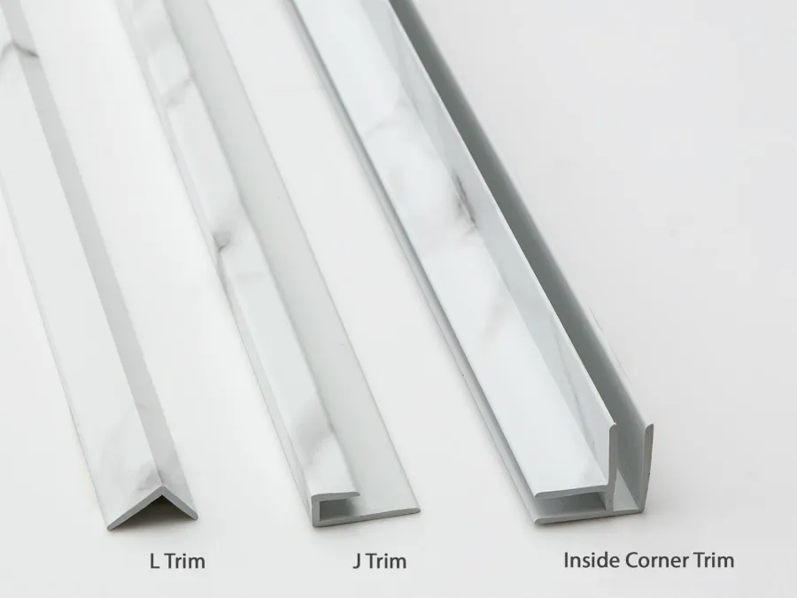 White carrara marble-patterned L trim, J trim, and inside corner trim for decorative edge finishing on surfaces.