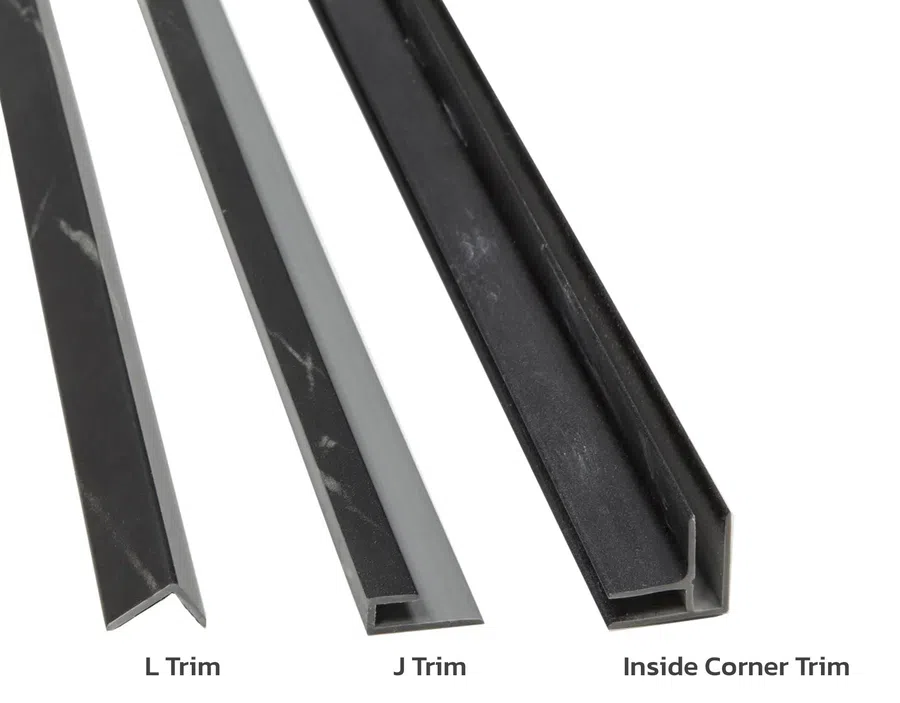 Three types of black and grey vinyl flooring trims labeled L Trim, J Trim, and Inside Corner Trim on white background.