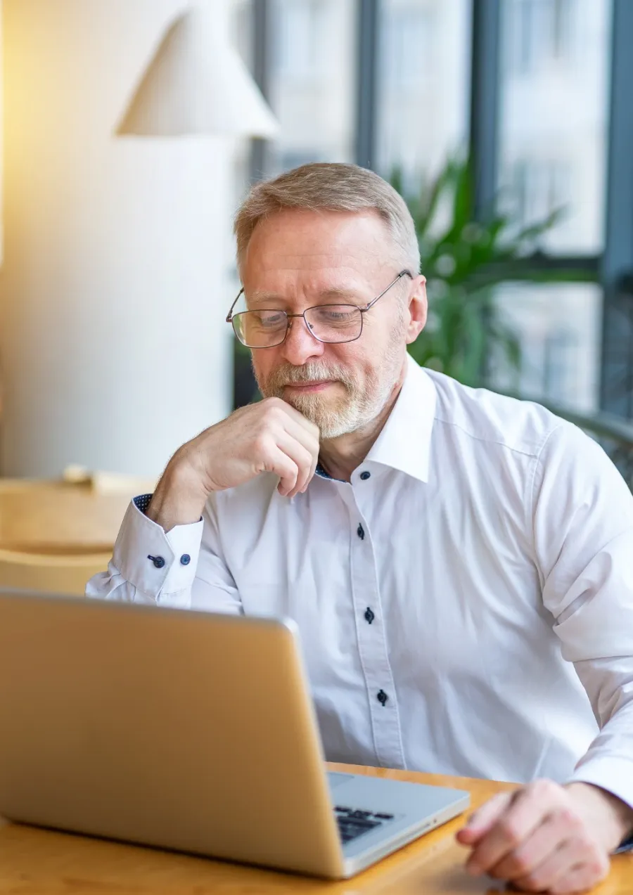 a man sitting at a table with his hand on his chin