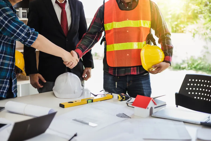 a man in a safety vest holding a hard hat