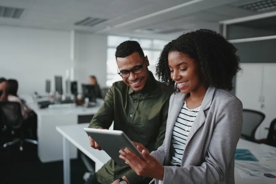 a man and a woman looking at a tablet