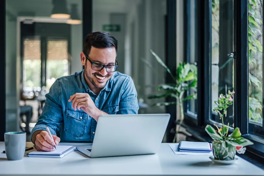 a man sitting at a table with a laptop