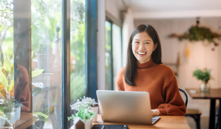 a woman sitting at a table with a laptop