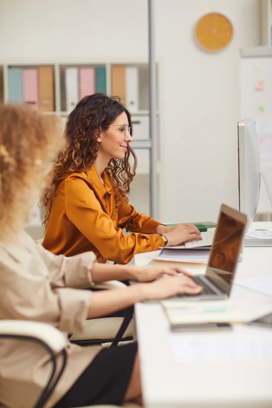 a woman showing something on the laptop to another woman