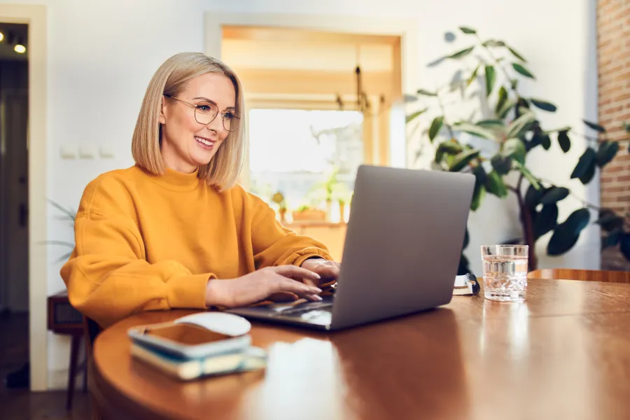 a woman sitting at a table using a laptop