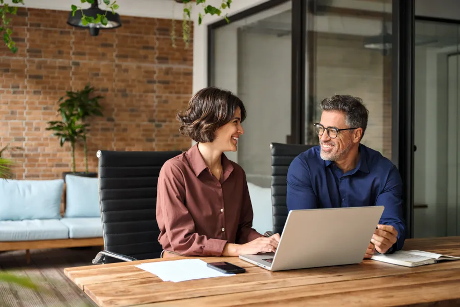 a man and a woman looking at a laptop