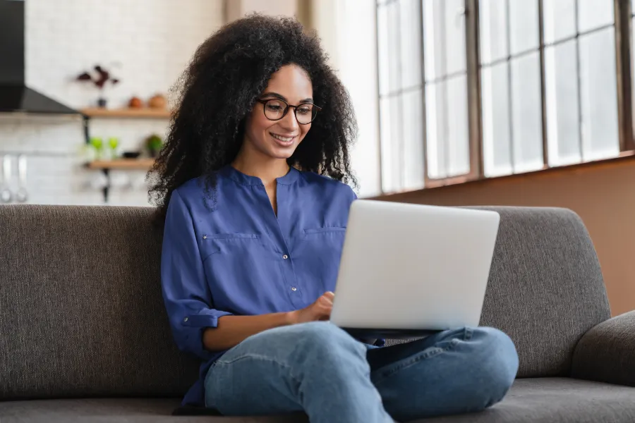 Swini Khara sitting on a couch with a laptop