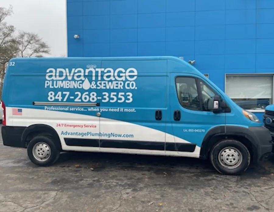 Blue and white Advantage Plumbing & Sewer Co. service van parked outside a blue building with contact details visible.