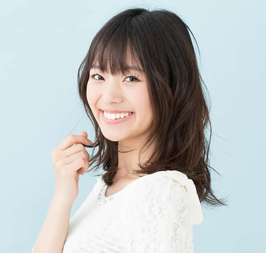 a woman smiling and holding a pen