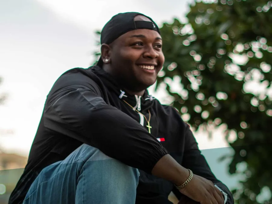 a man smiling and sitting on a bench