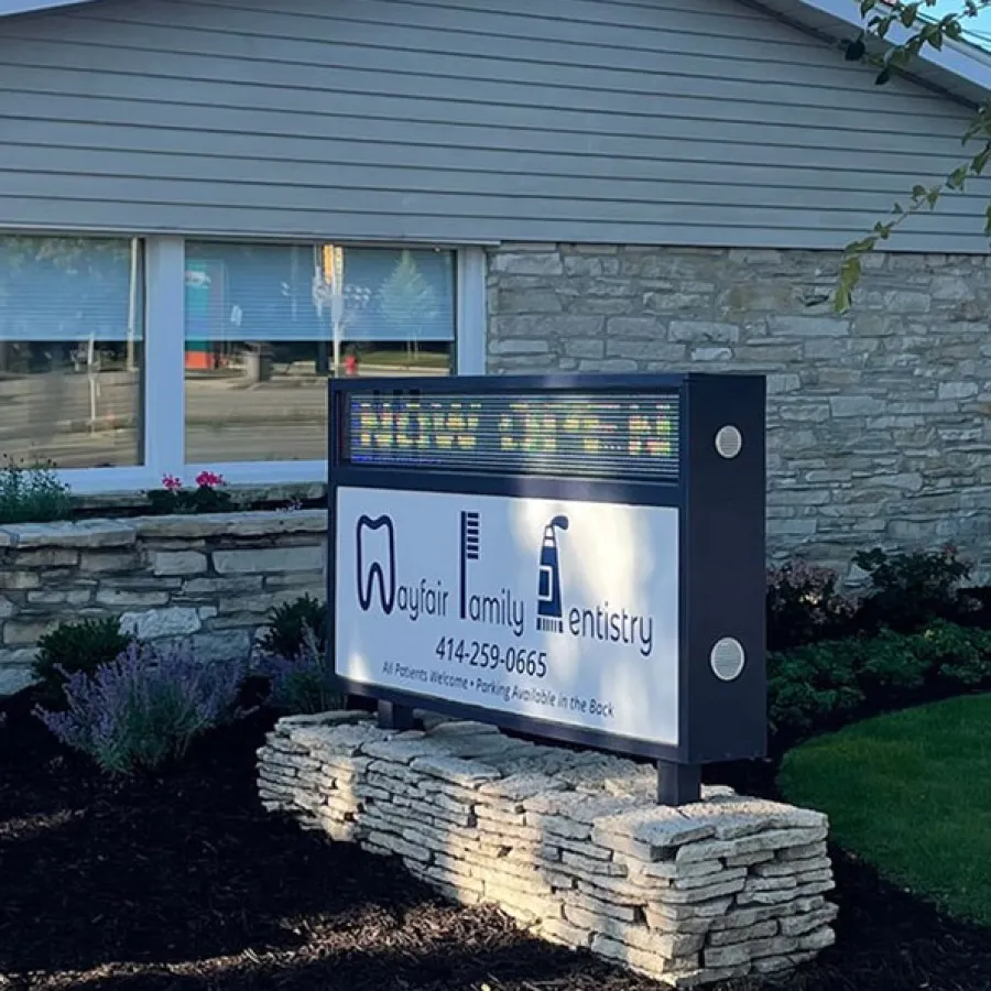 Wayfair Family Dentistry building exterior with stone facade and illuminated sign at entrance