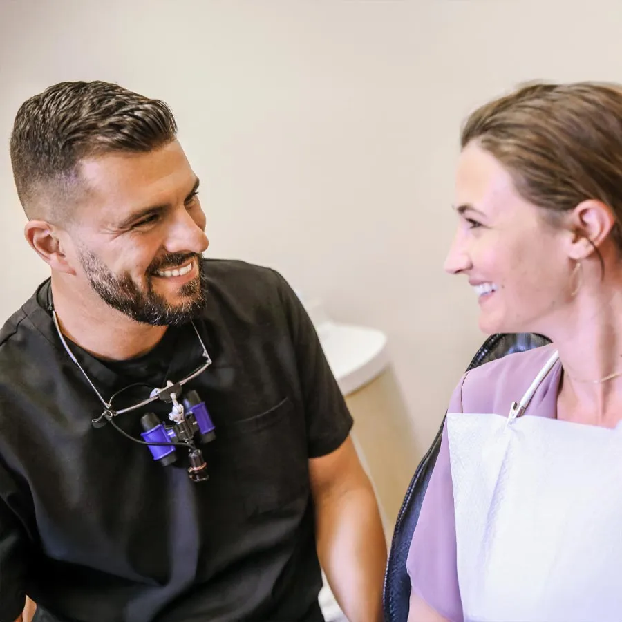 Smiling woman at dental appointment, feeling relaxed and happy in a modern clinic.