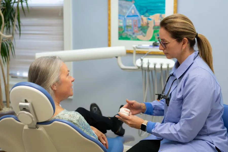 Dentist explaining dental impression to mature female patient in dental office consultation