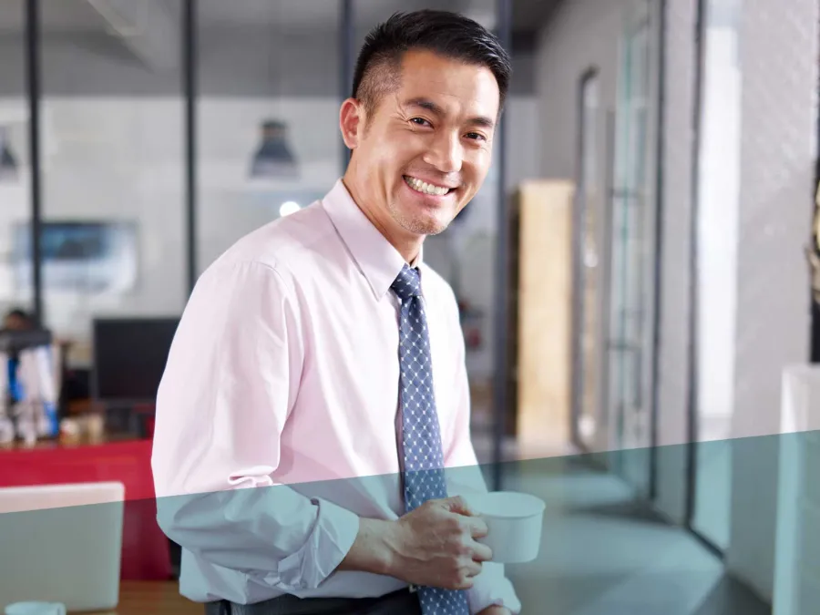 a man holding a cup and smiling