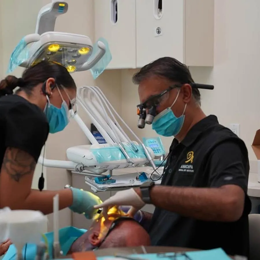 Dentist performing oral surgery with assistance in a modern dental clinic setup.