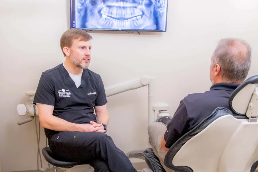 a person sitting in a chair next to another man